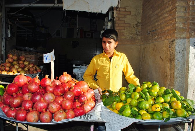 Irański chłopiec sprzedający owoce w mieście Kashan.