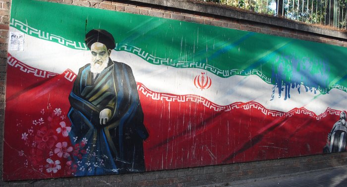 Ajatollah Chomeini na tle flagi Iranu.