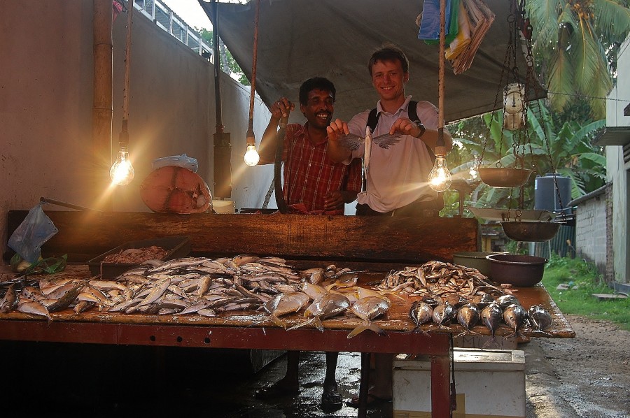 Na bazarze rybnym w Hikkaduwa, z latającą rybę w rękach. Sri Lanka.