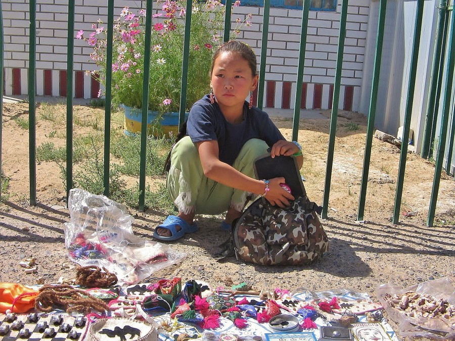 Mongolska dziewczynka na pustyni Gobi sprzedająca pamiątki. 