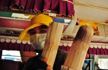 Kambodża - kobieta w masce sprzedaje ryż w bambusach.