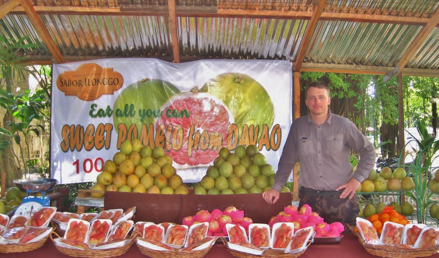 At the bazaar in the Philippines,in front of pomelos. Quite often, this fruit is sold on trays, so there is no need to peel.